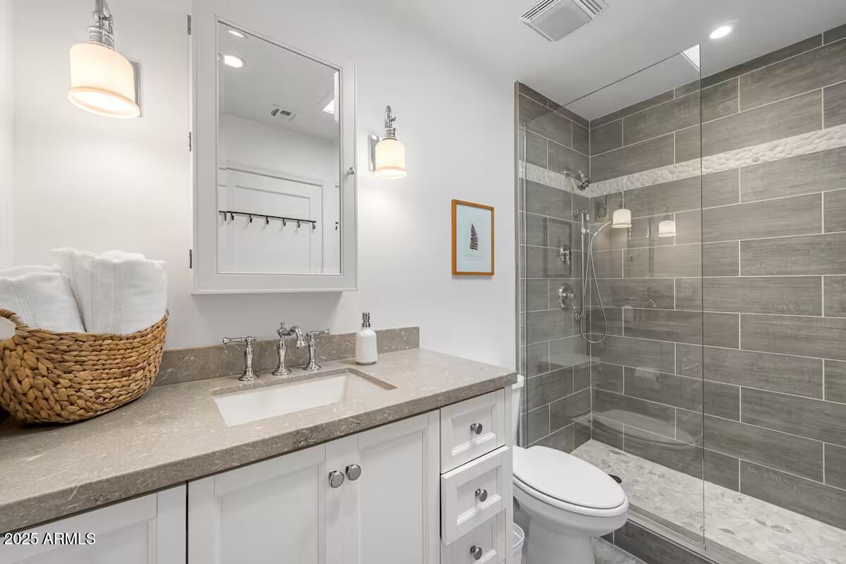 49 Prochnow Road Sedona, AZ 86336 - Photo 49 of 76 a bathroom with a granite countertop sink a toilet a mirror a vanity and shower