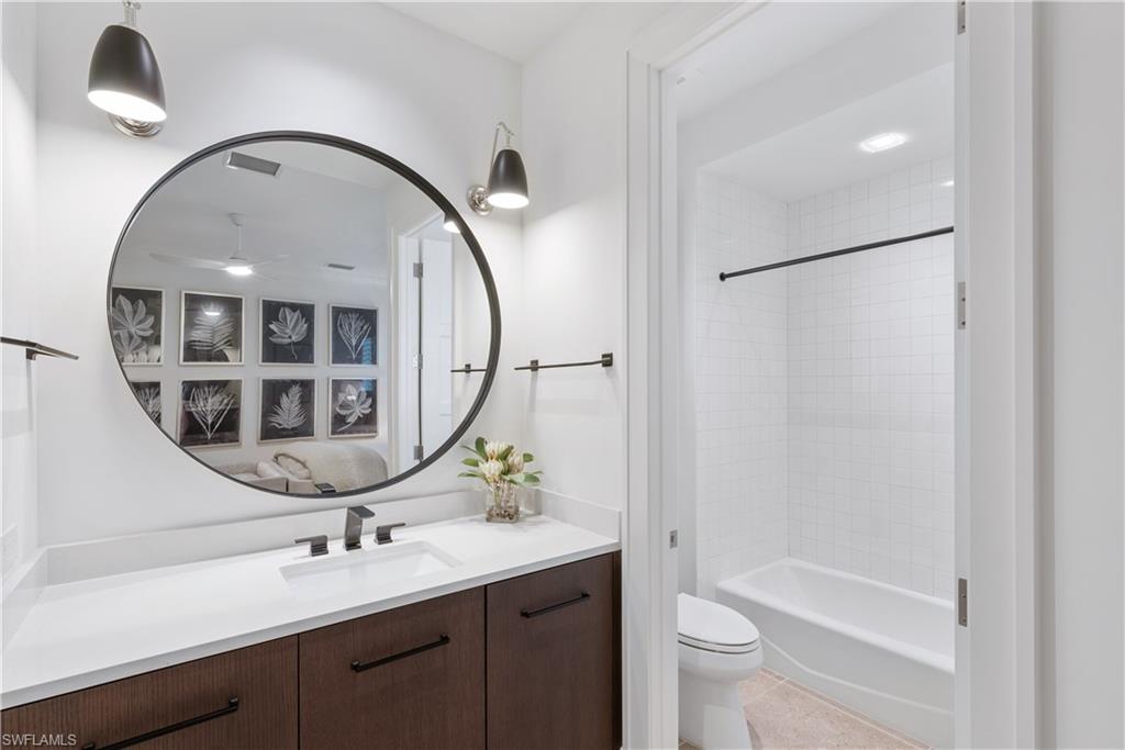4220 Crayton Road Naples, FL 34103 - Photo 14 of 27 a bathroom with a sink a toilet and a mirror
