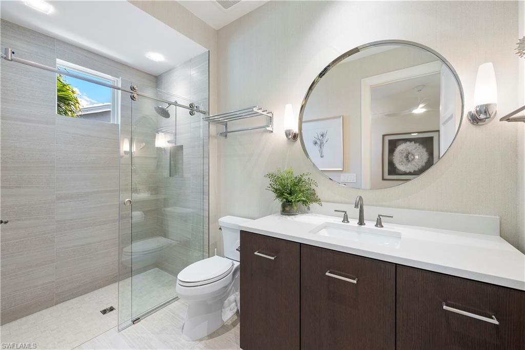 4220 Crayton Road Naples, FL 34103 - Photo 16 of 27 a bathroom with a toilet a sink and mirror