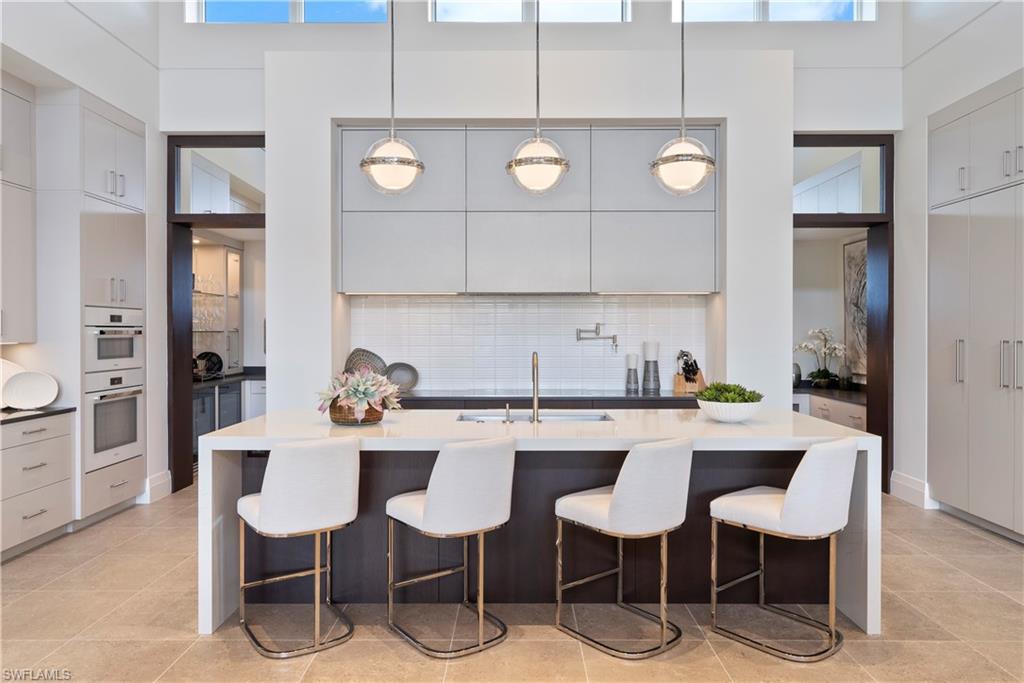 4220 Crayton Road Naples, FL 34103 - Photo 7 of 27 a kitchen with a dining table and chairs