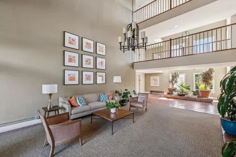 a living room with furniture and a chandelier
