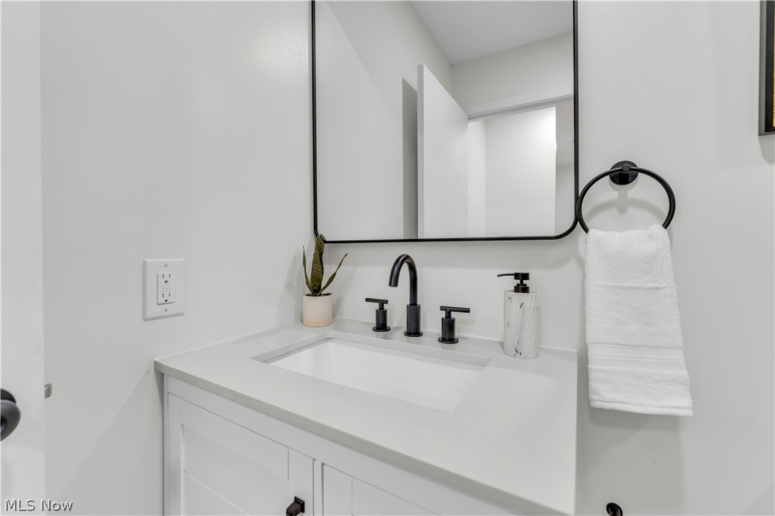 10763 Gate Post Road Strongsville, OH 44149 - Photo 36 of 45 White vanity featuring a single basin, light-toned countertop, and matte black fixtures