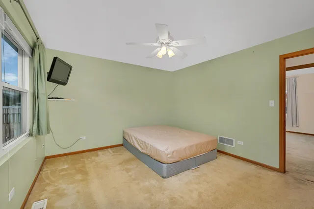 a view of an empty room with a chandelier fan