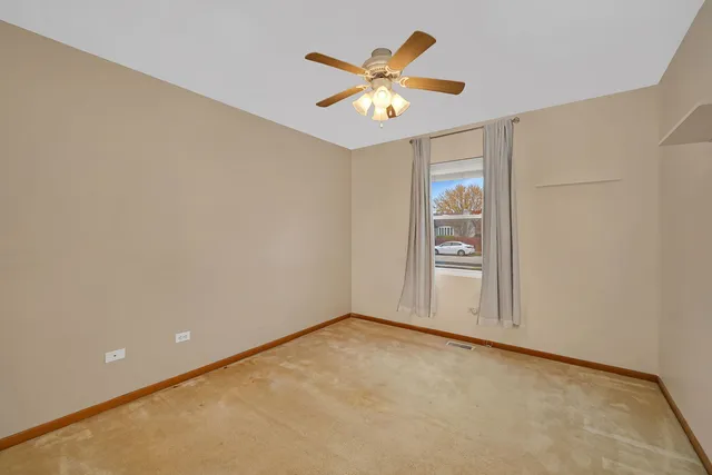 an empty room with closet and fan