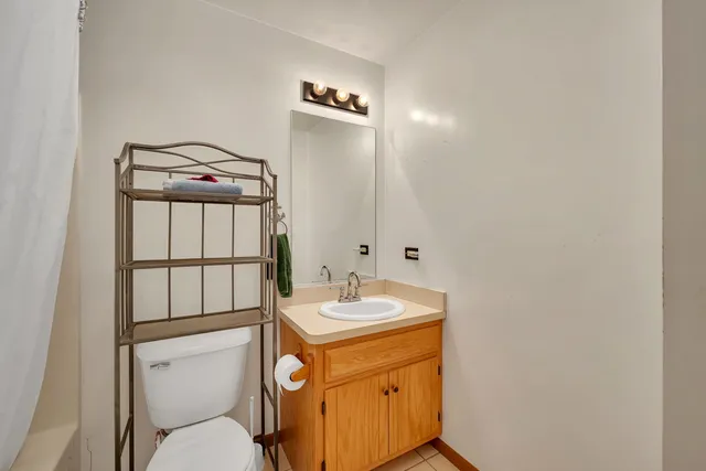 a bathroom with a granite countertop sink toilet and mirror