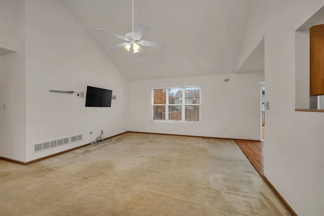 en empty room with windows and ceiling fan