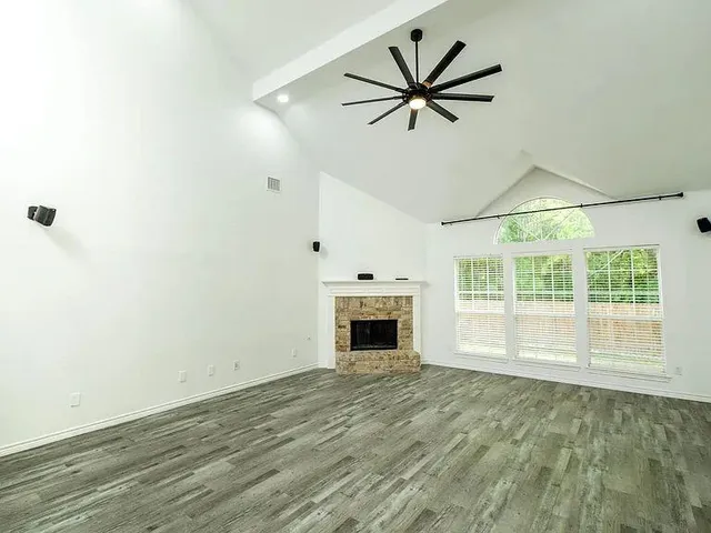 a view of an empty room with a fireplace and a window
