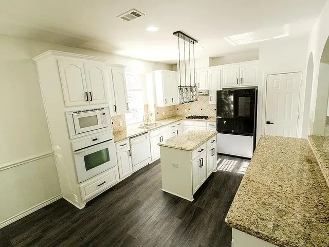 a kitchen with white cabinets and white appliances