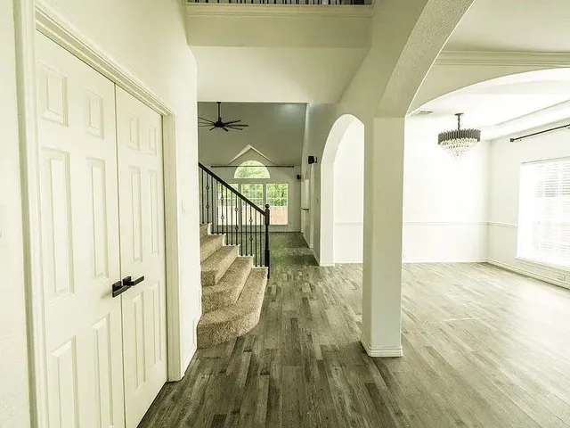 a view of a hallway with wooden floor and staircase