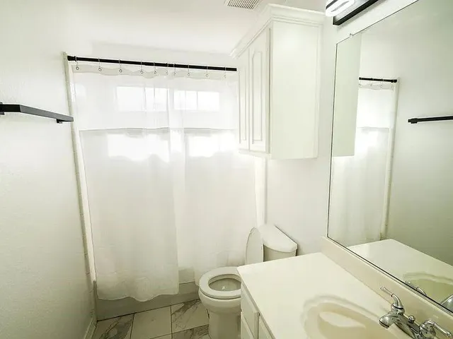 a bathroom with a sink toilet and shower