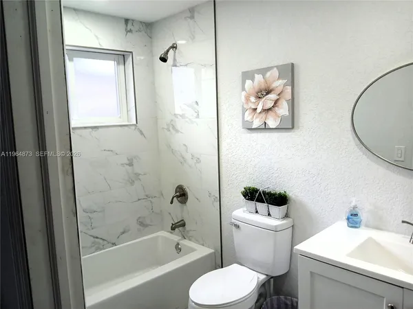 a white toilet sitting next to a bathroom sink and tub