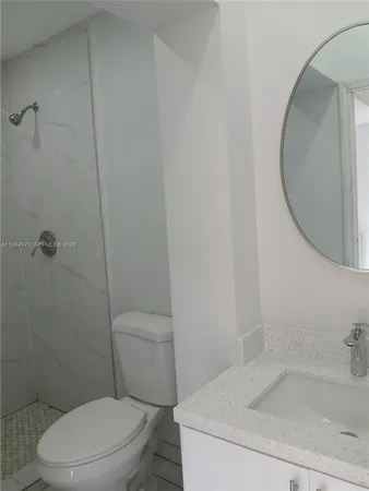 a white toilet sitting next to a bath tub