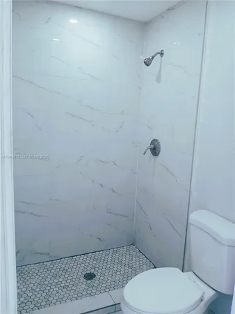 a bathroom with a toilet and a shower