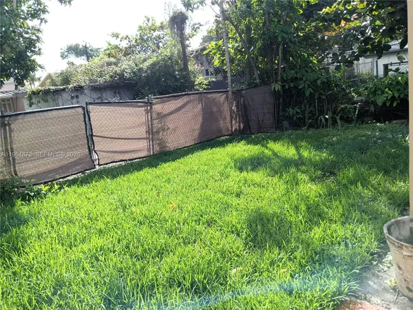 a view of backyard with wooden fence