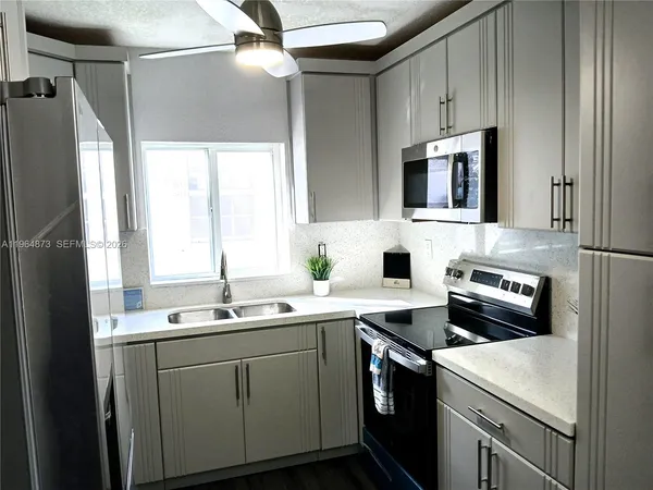 a kitchen with a sink cabinets and stainless steel appliances