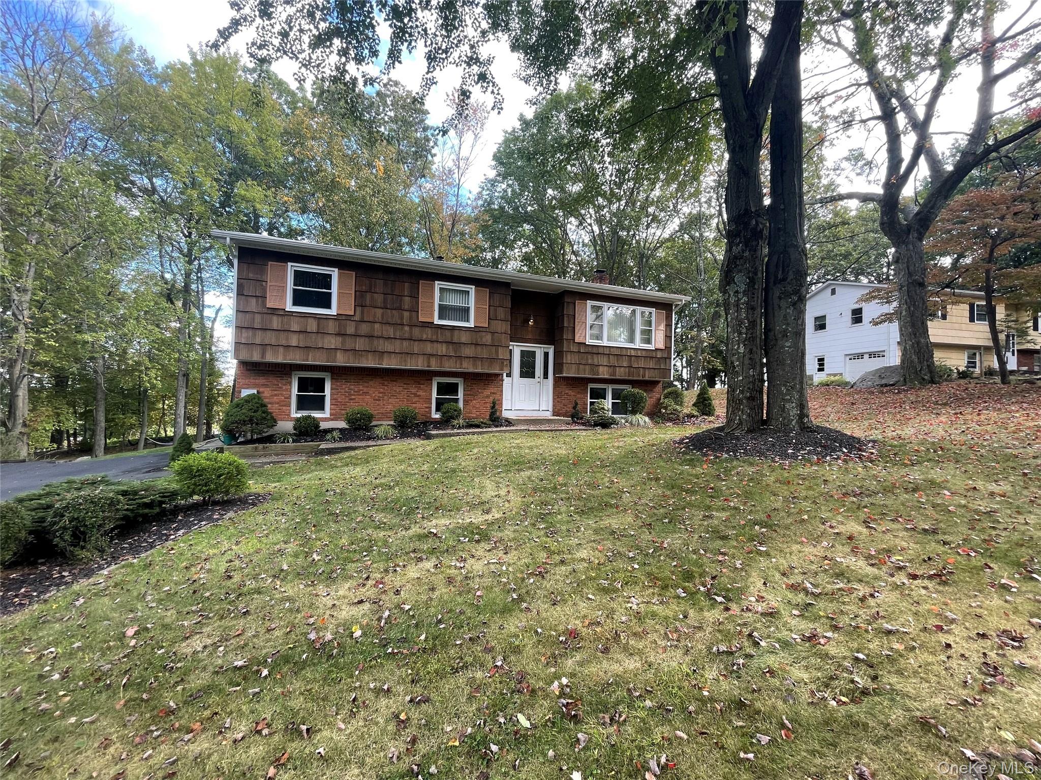 Split foyer home featuring a front lawn and brick siding