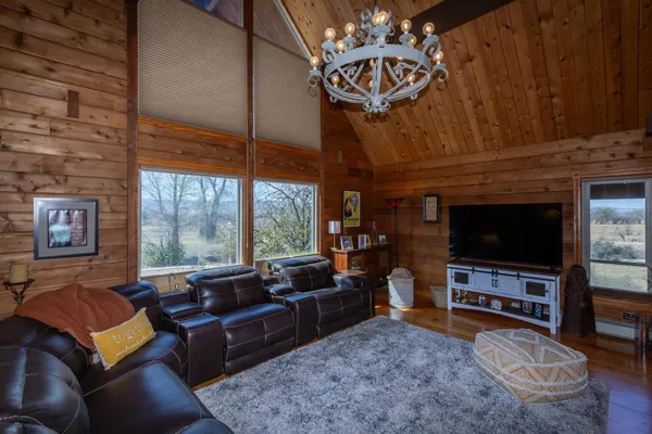 a living room with furniture a chandelier and a fireplace