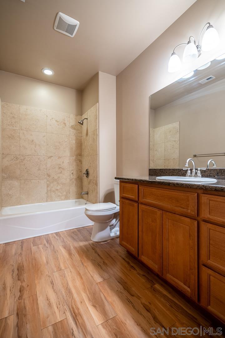 483 Alpine Trail Road Alpine, CA 91901 - Photo 23 of 42 a bathroom with a granite countertop sink a toilet a mirror and bathtub