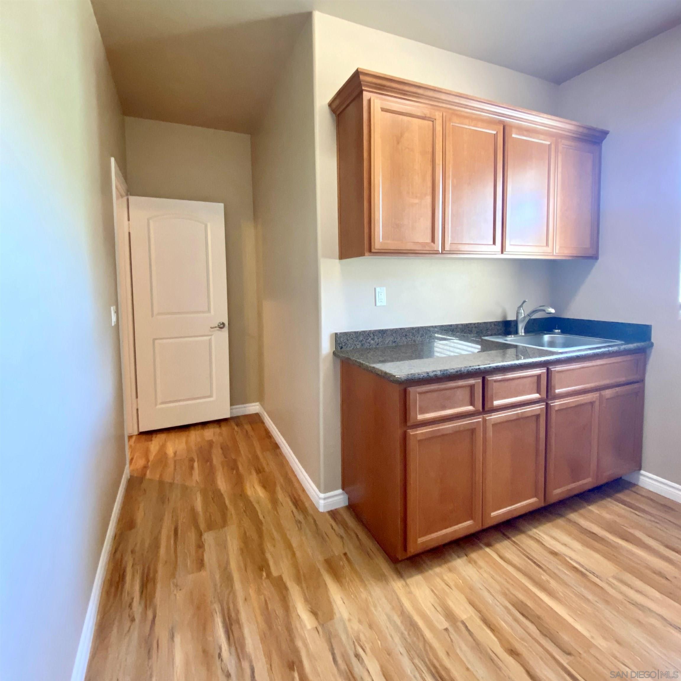 483 Alpine Trail Road Alpine, CA 91901 - Photo 26 of 42 a kitchen with wooden floors and cabinets