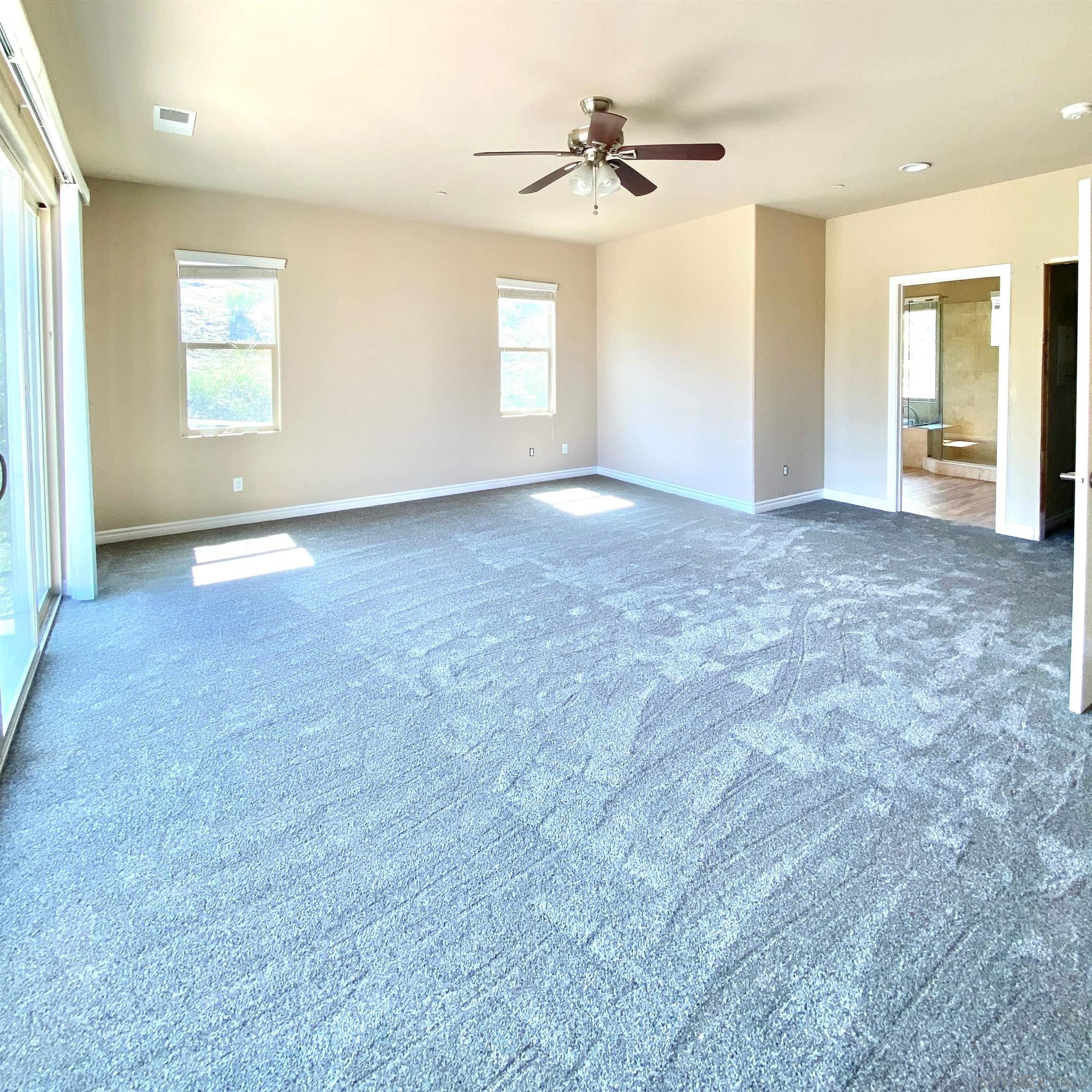 483 Alpine Trail Road Alpine, CA 91901 - Photo 30 of 42 an empty room with windows and ceiling fan