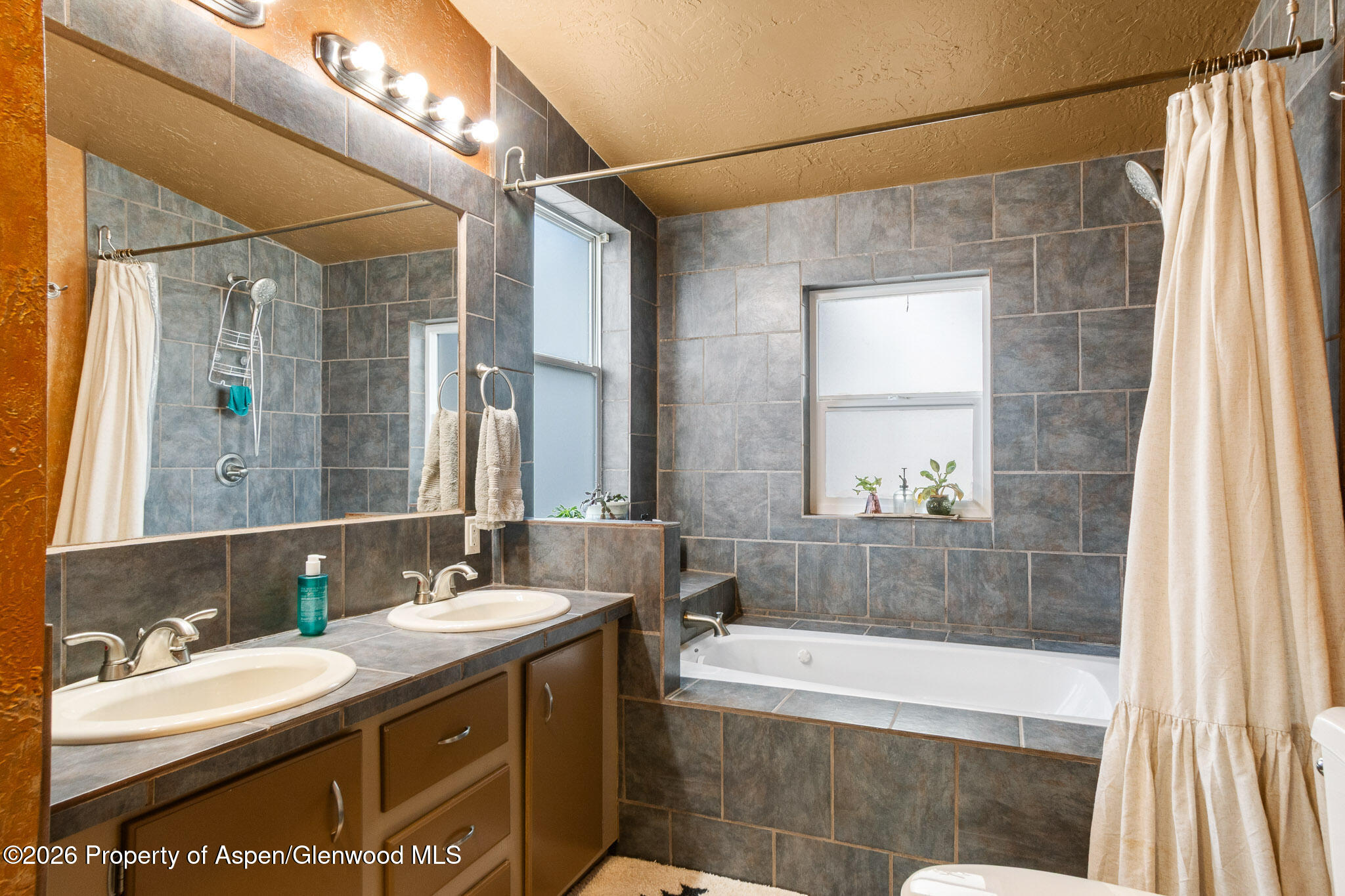 106 Cedar Circle Parachute, CO 81635 - Photo 23 of 35 a bathroom with a granite countertop sink mirror bathtub and shower