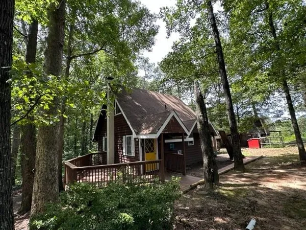 an aerial view of a house with swimming pool and trees