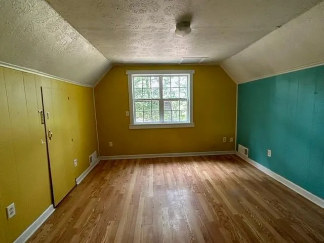 a view of an empty room with glass door and a window