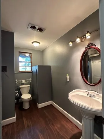 a bathroom with a toilet a sink and mirror