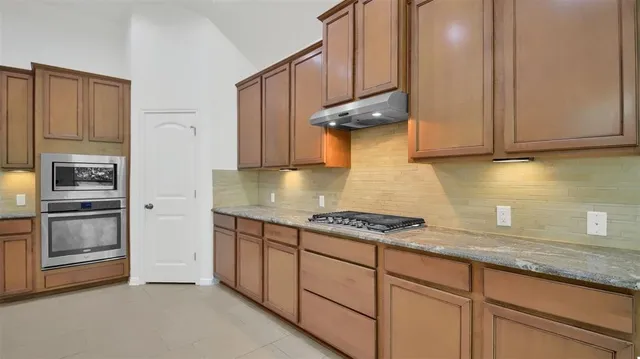 a kitchen with stainless steel appliances granite countertop a stove and a refrigerator