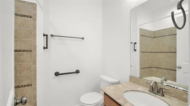 a bathroom with a granite countertop sink toilet and shower
