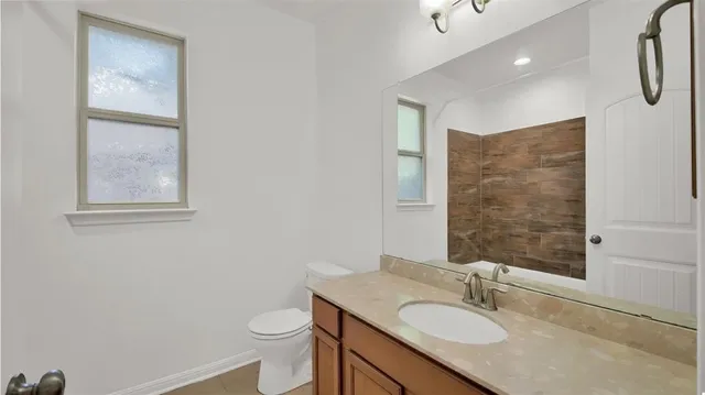 a bathroom with a granite countertop sink toilet and shower