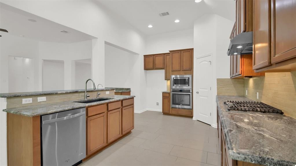 104 Lost Ridge Way Buda, TX 78610 - Photo 15 of 22 a kitchen with stainless steel appliances granite countertop a refrigerator and a stove top oven