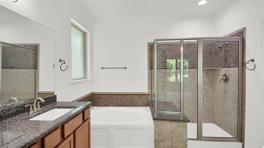 104 Lost Ridge Way Buda, TX 78610 - Photo 17 of 22 a bathroom with a granite countertop sink a mirror and shower