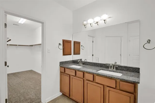 a bathroom with a granite countertop sink a mirror and a vanity