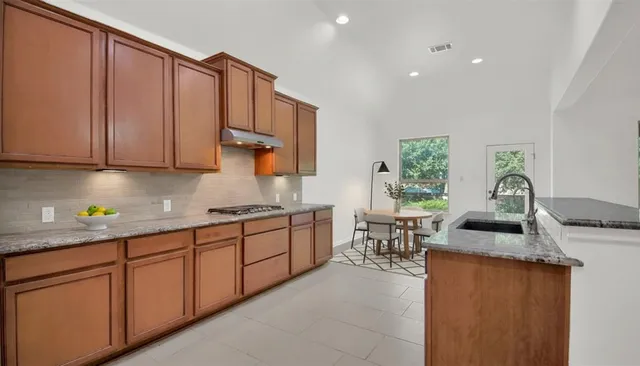 a kitchen with granite countertop sink cabinets and window