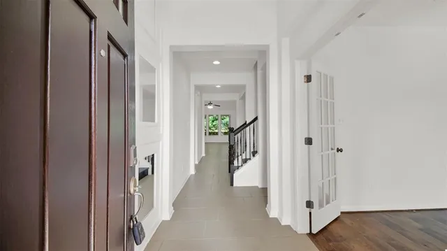 a view of a hallway with wooden floor and a livingroom
