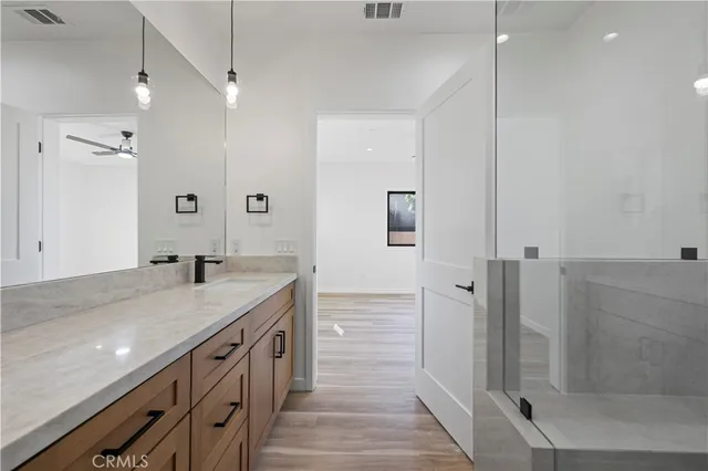a bathroom with a granite countertop sink a shower and a mirror