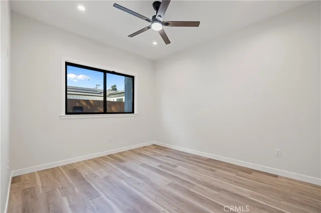 an empty room with a window and ceiling fan