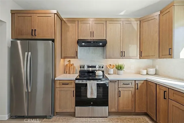a kitchen with stainless steel appliances granite countertop a stove a refrigerator and a sink