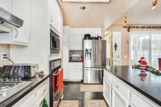 a kitchen with stainless steel appliances granite countertop a refrigerator and a sink