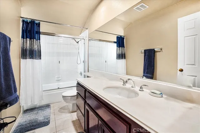 a bathroom with a granite countertop sink a toilet a mirror and shower