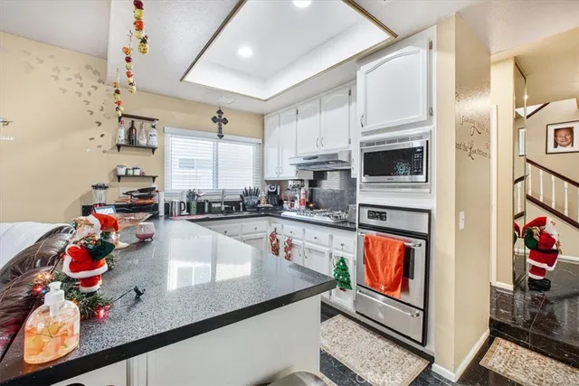 a kitchen with stainless steel appliances granite countertop a sink dishwasher and cabinets with wooden floor