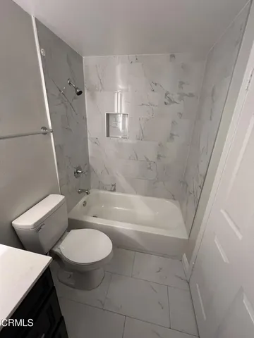 a bathroom with a granite countertop toilet sink and bathtub
