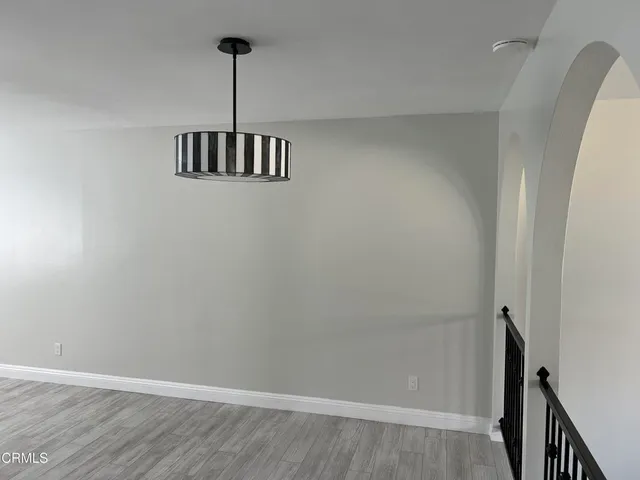 a view of a room with wooden floor and a ceiling fan