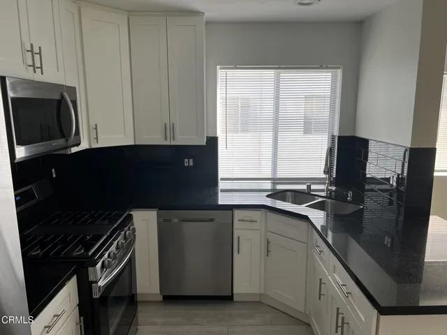 a kitchen with a sink stove and microwave