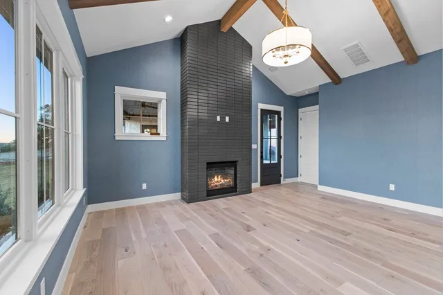 a view of an empty room with a window and fire place