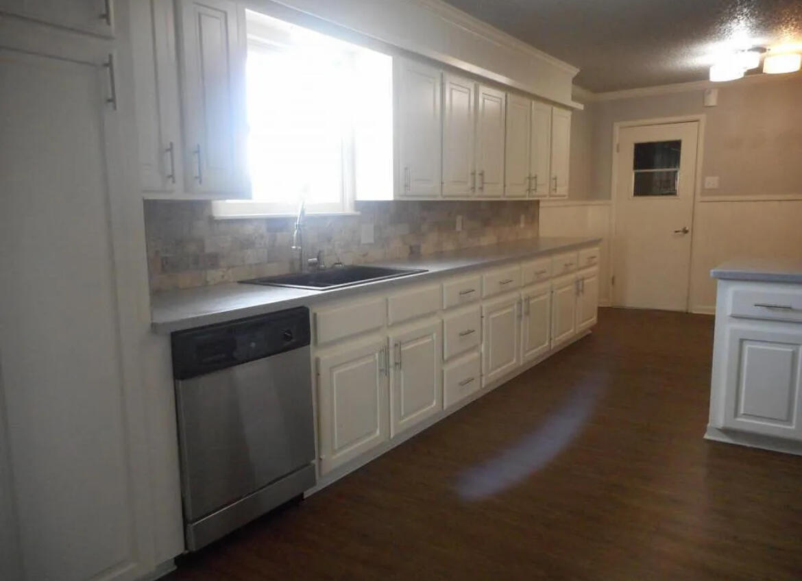 4901 12th Street Lubbock, TX 79416 - Photo 4 of 7 a kitchen with sink cabinets and window