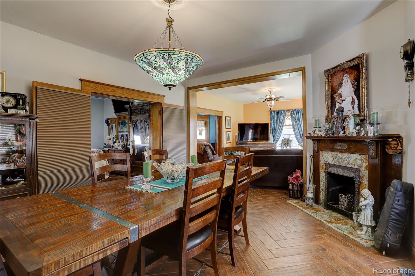 153 Park Avenue Fort Lupton, CO 80621 - Photo 13 of 35 a view of a dining room with furniture a fireplace and wooden floor