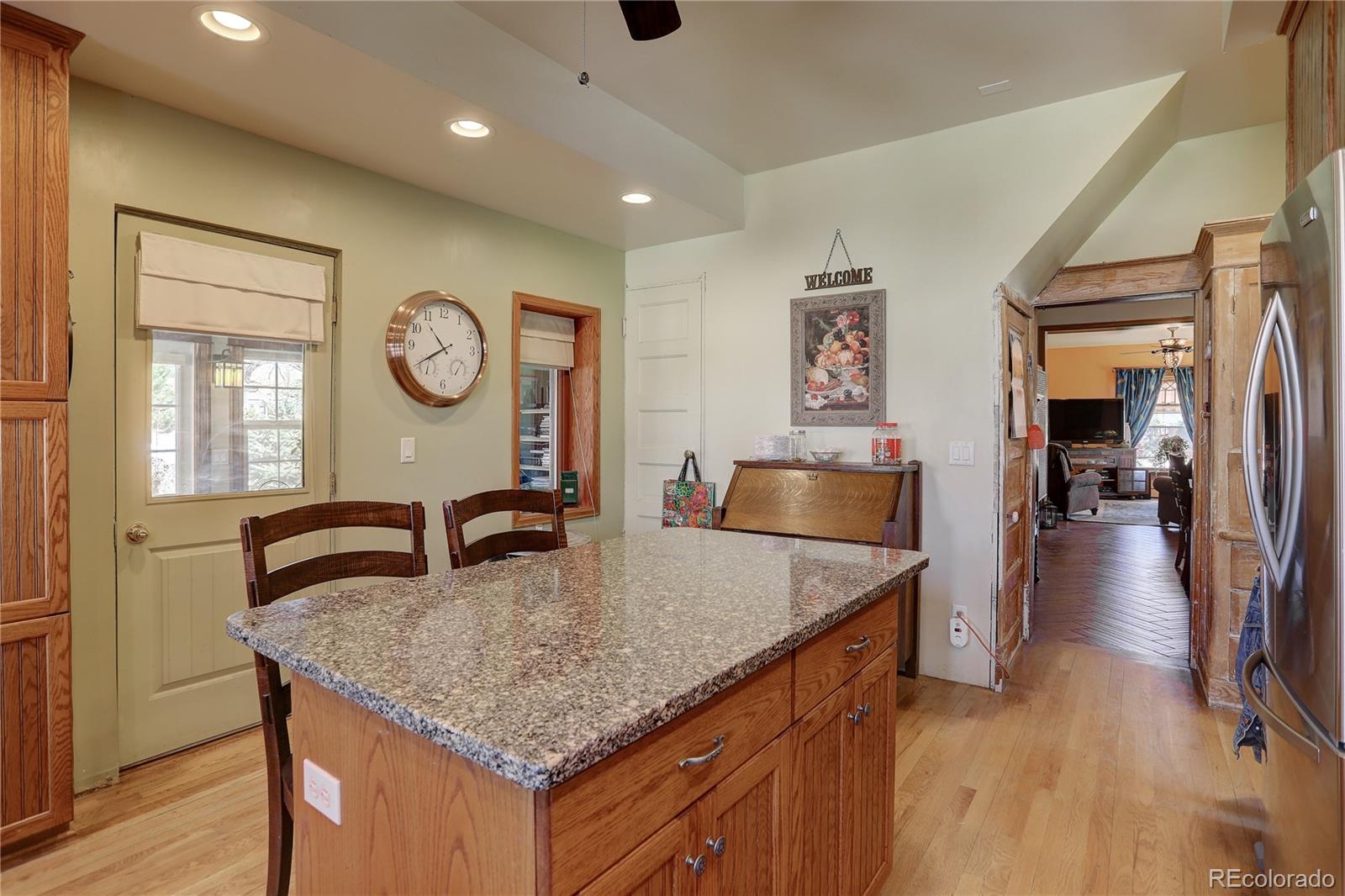153 Park Avenue Fort Lupton, CO 80621 - Photo 14 of 35 a kitchen with granite countertop a table and chairs in it