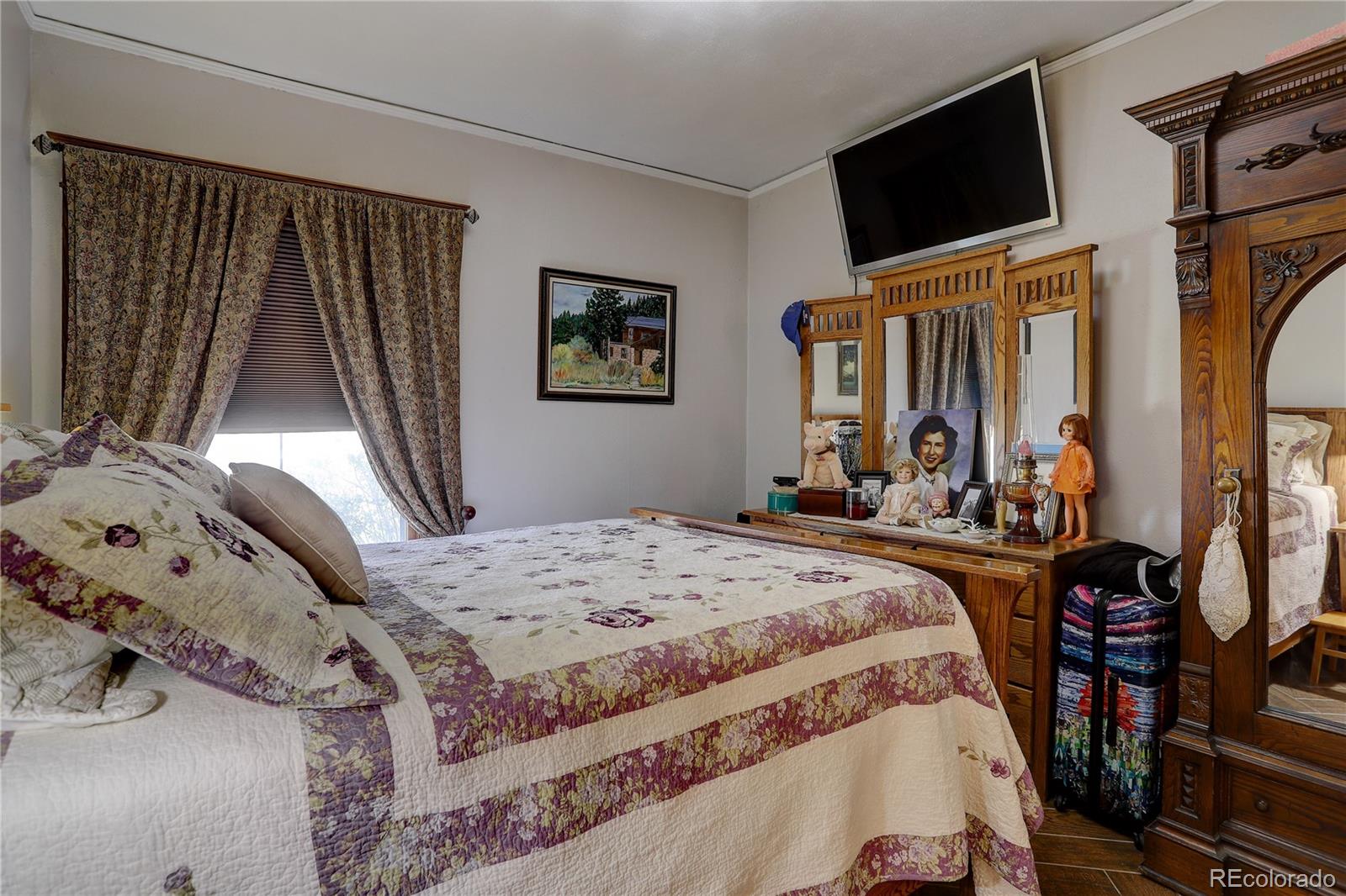 153 Park Avenue Fort Lupton, CO 80621 - Photo 17 of 35 a bedroom with a bed a flat screen tv and dresser